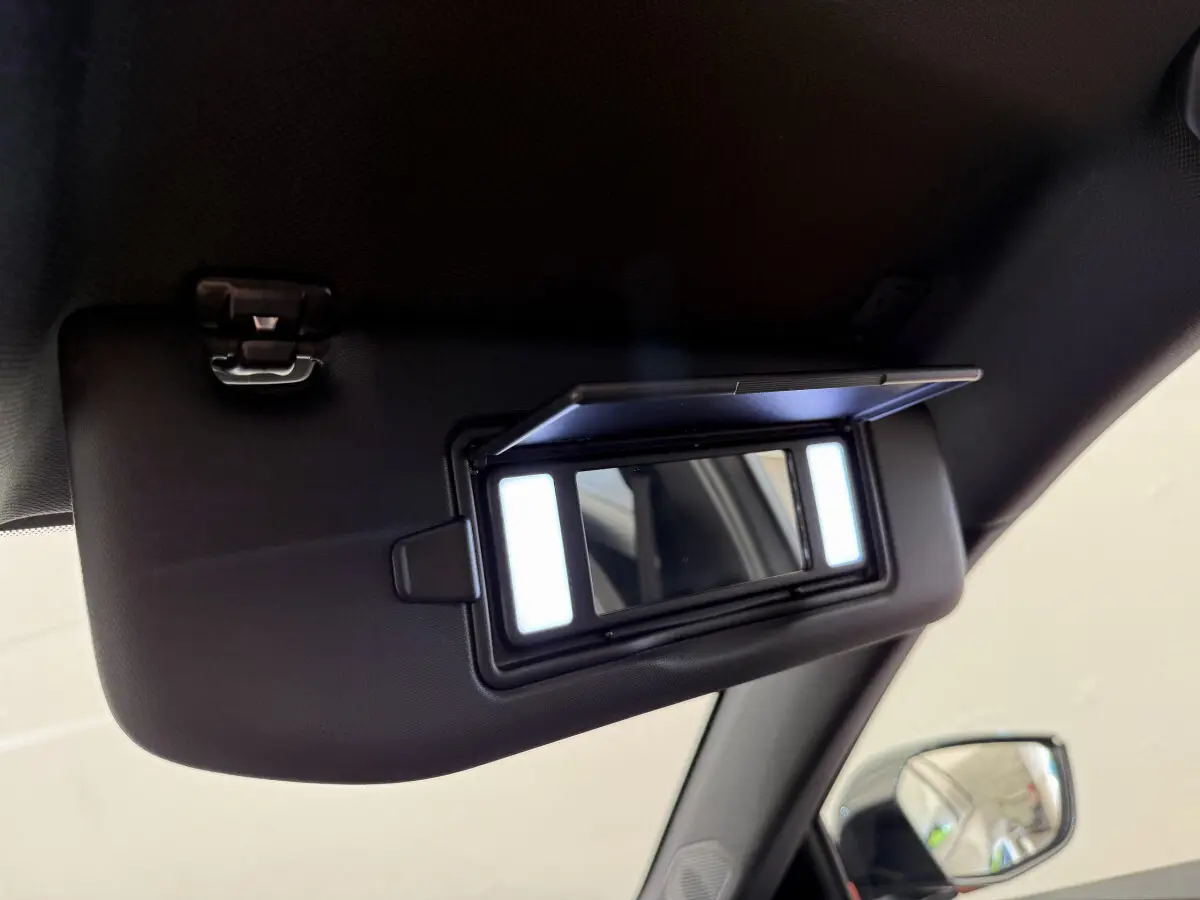 Miroir de courtoisie éclairé sur pare-soleil côté conducteur dans Peugeot 308 Hybrid gris foncé, vue intérieure rapprochée.