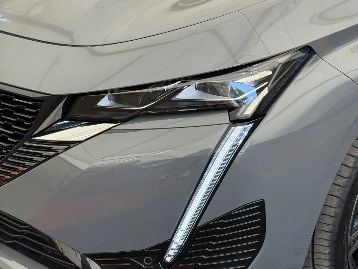 Gros plan sur le phare avant droit LED du Peugeot 308 Hybrid 136 e-DCS6 GT gris foncé 2024.