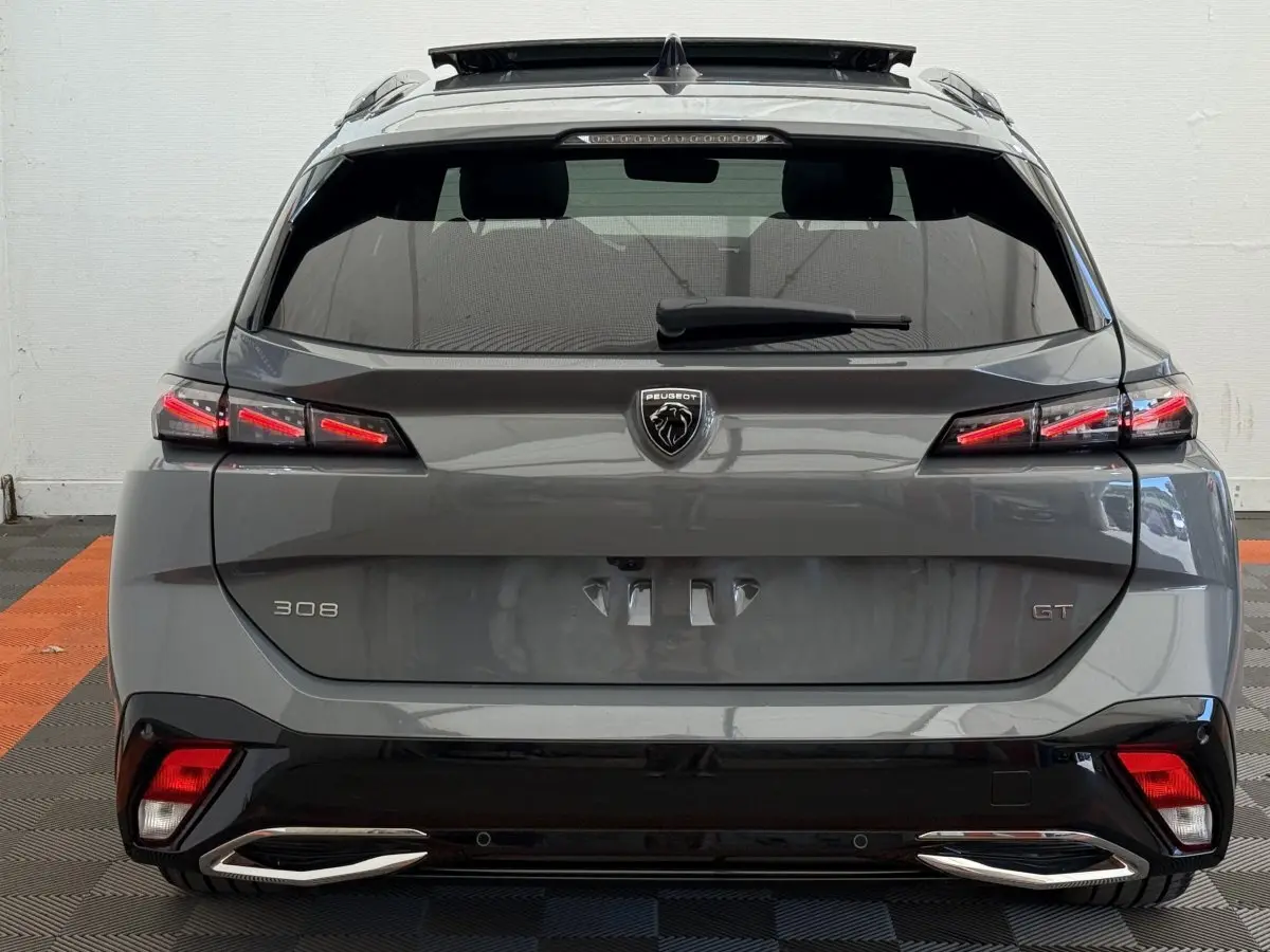 Vue arrière d'une Peugeot 308 GT gris foncé avec feux LED et double sortie d'échappement chromée.