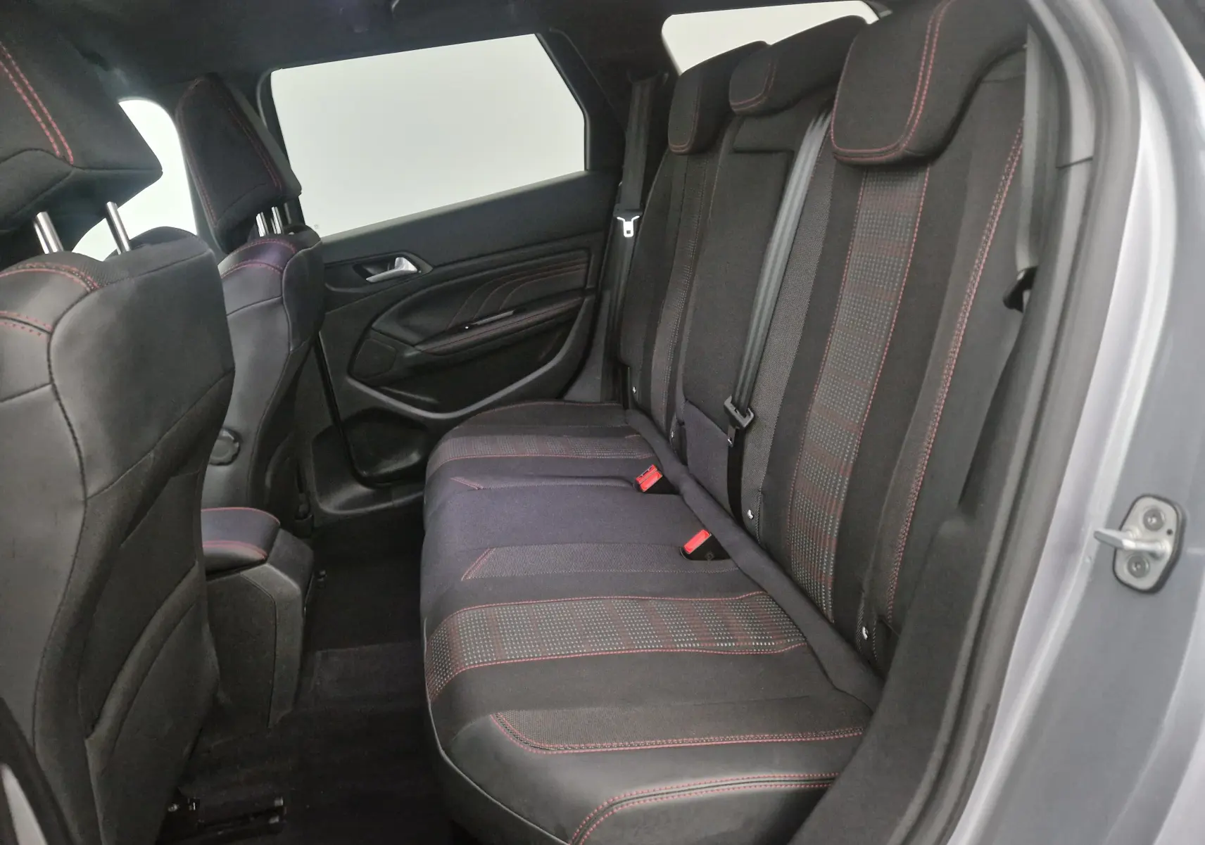 Vue intérieure côté droit des sièges arrière noirs avec surpiqûres rouges du Peugeot 308 SW gris Artense 2019.