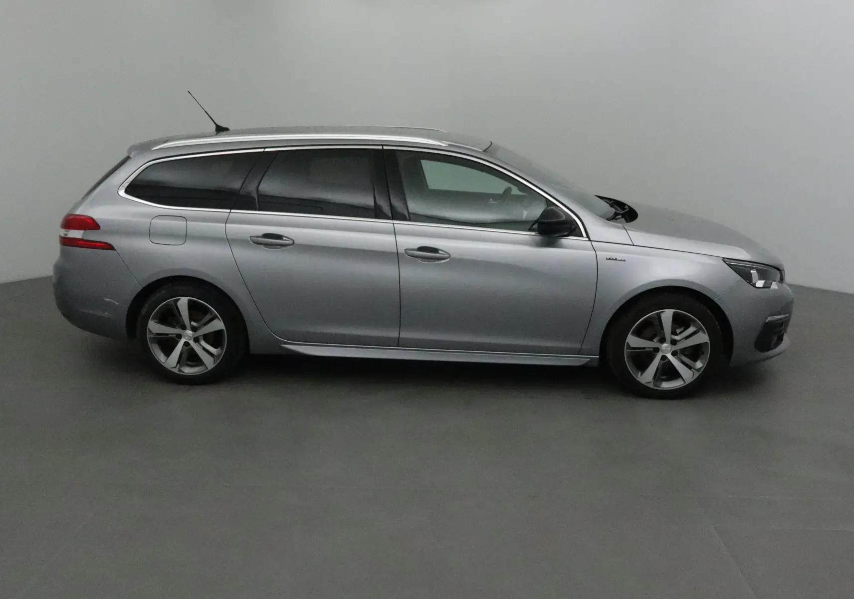 Peugeot 308 SW gris Artense vue de profil côté gauche, avec jantes alliage et vitres teintées.