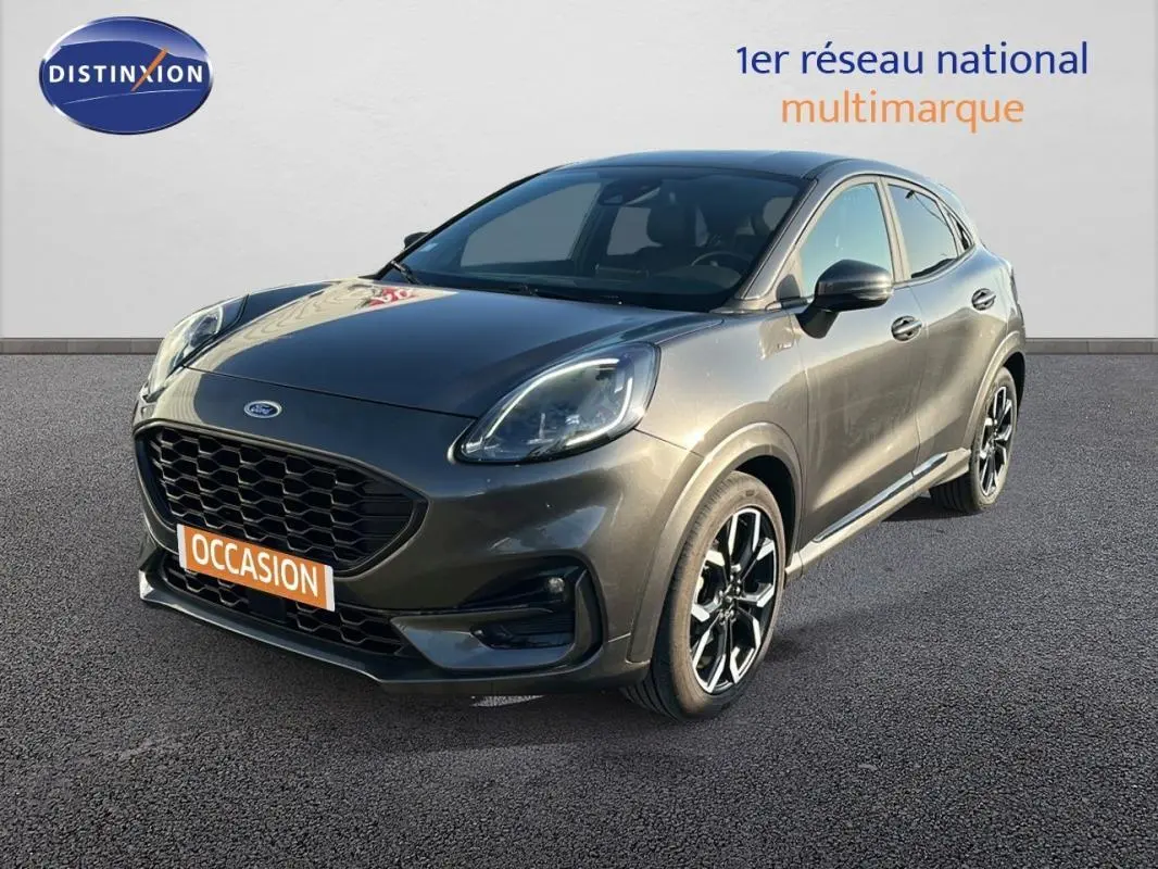 Vue 3/4 avant d'une Ford Puma gris foncé avec jantes alliage noires et vitres surteintées sur fond neutre.