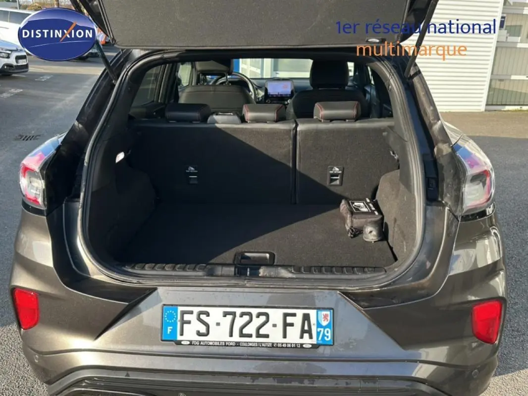 Vue arrière ouverte du Ford Puma gris foncé 2020, montrant le coffre spacieux et les feux arrière.