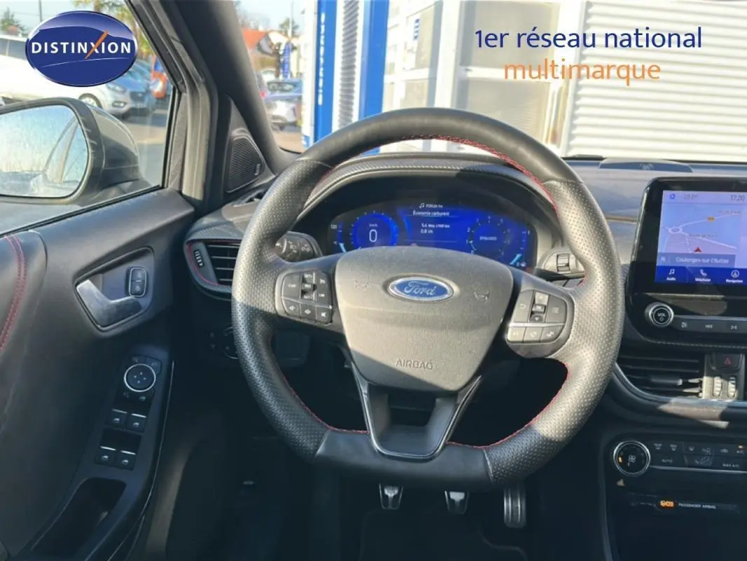 Vue intérieure centrée sur le volant et tableau de bord numérique du Ford Puma gris foncé avec écran tactile GPS.