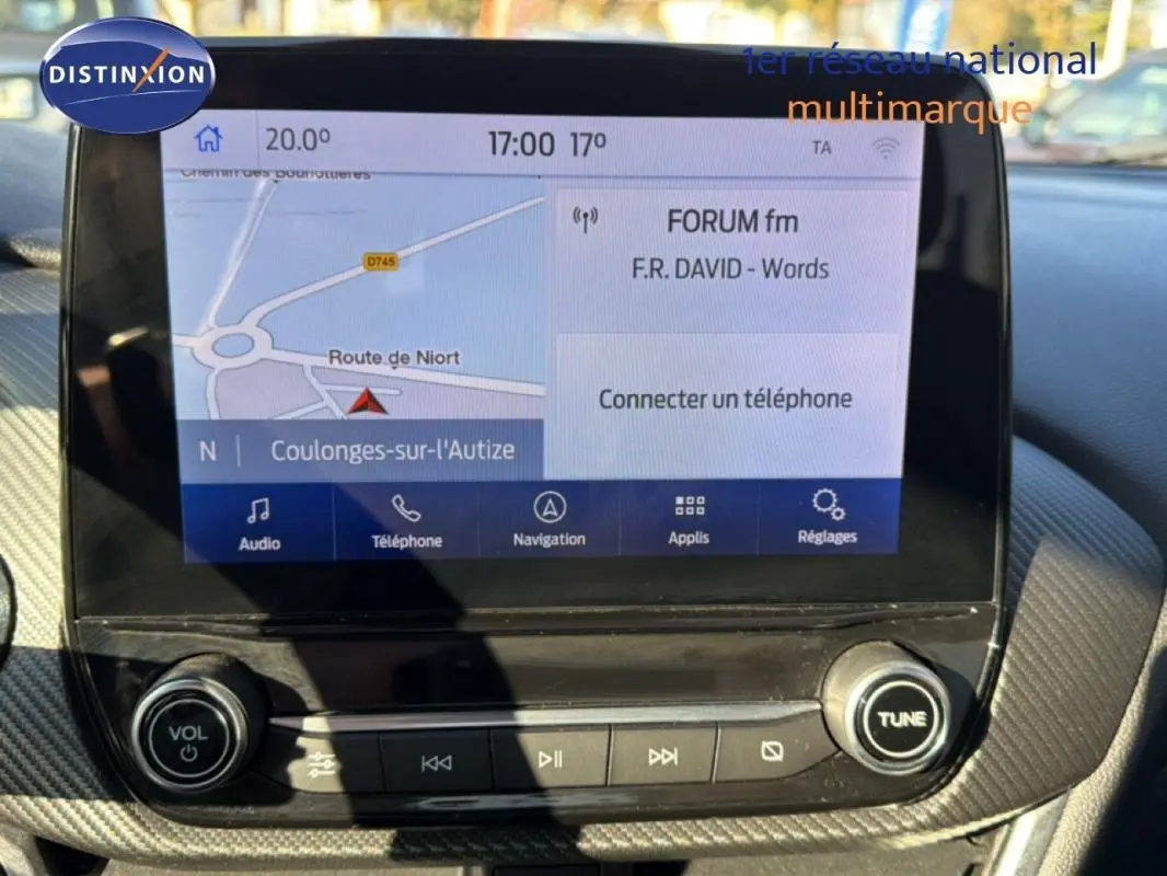 Écran tactile central du Ford Puma 2020 affichant la navigation et la radio, avec commandes audio en bas.