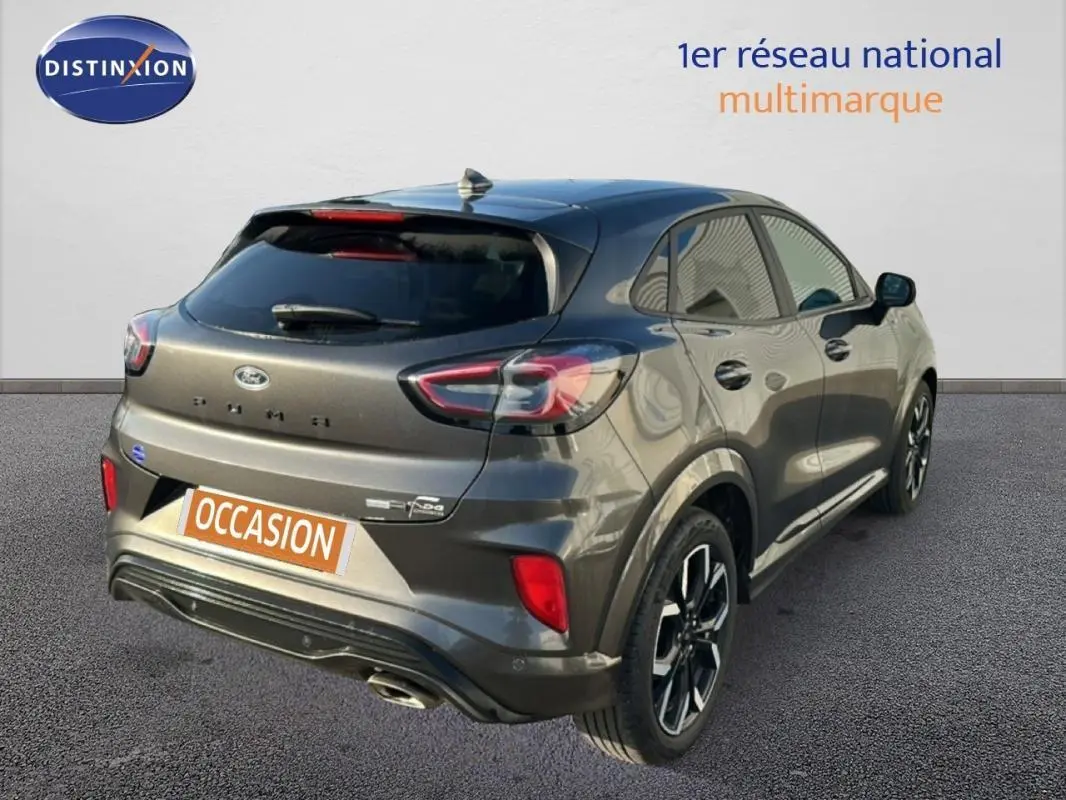 Vue 3/4 arrière droite d'un Ford Puma gris foncé avec jantes alliage 18 pouces et vitres surteintées.