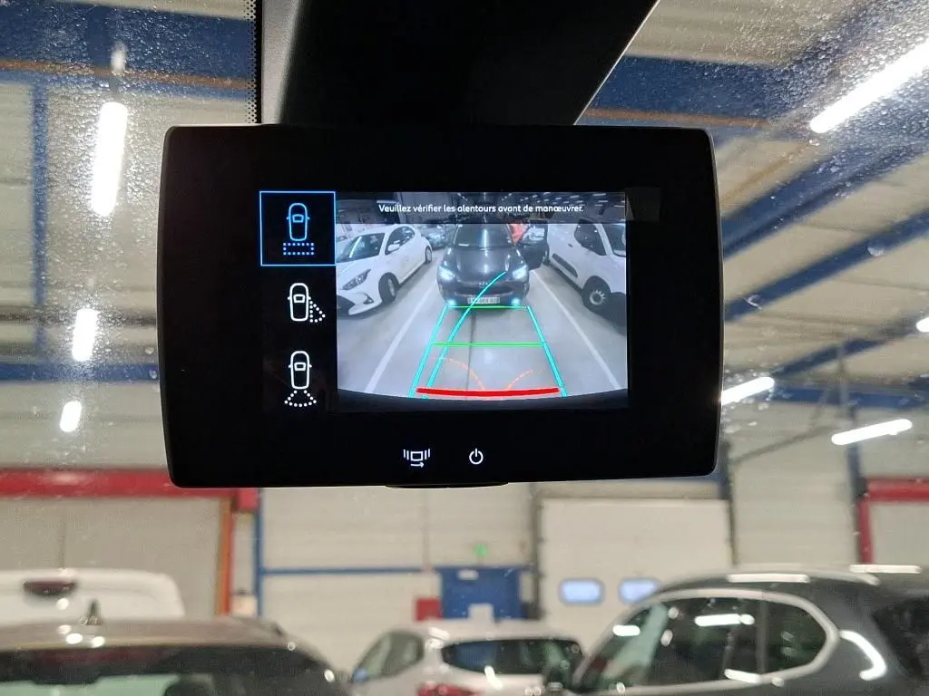 Écran de caméra de recul montrant une vue arrière du Peugeot Partner Fourgon blanc en parking intérieur.