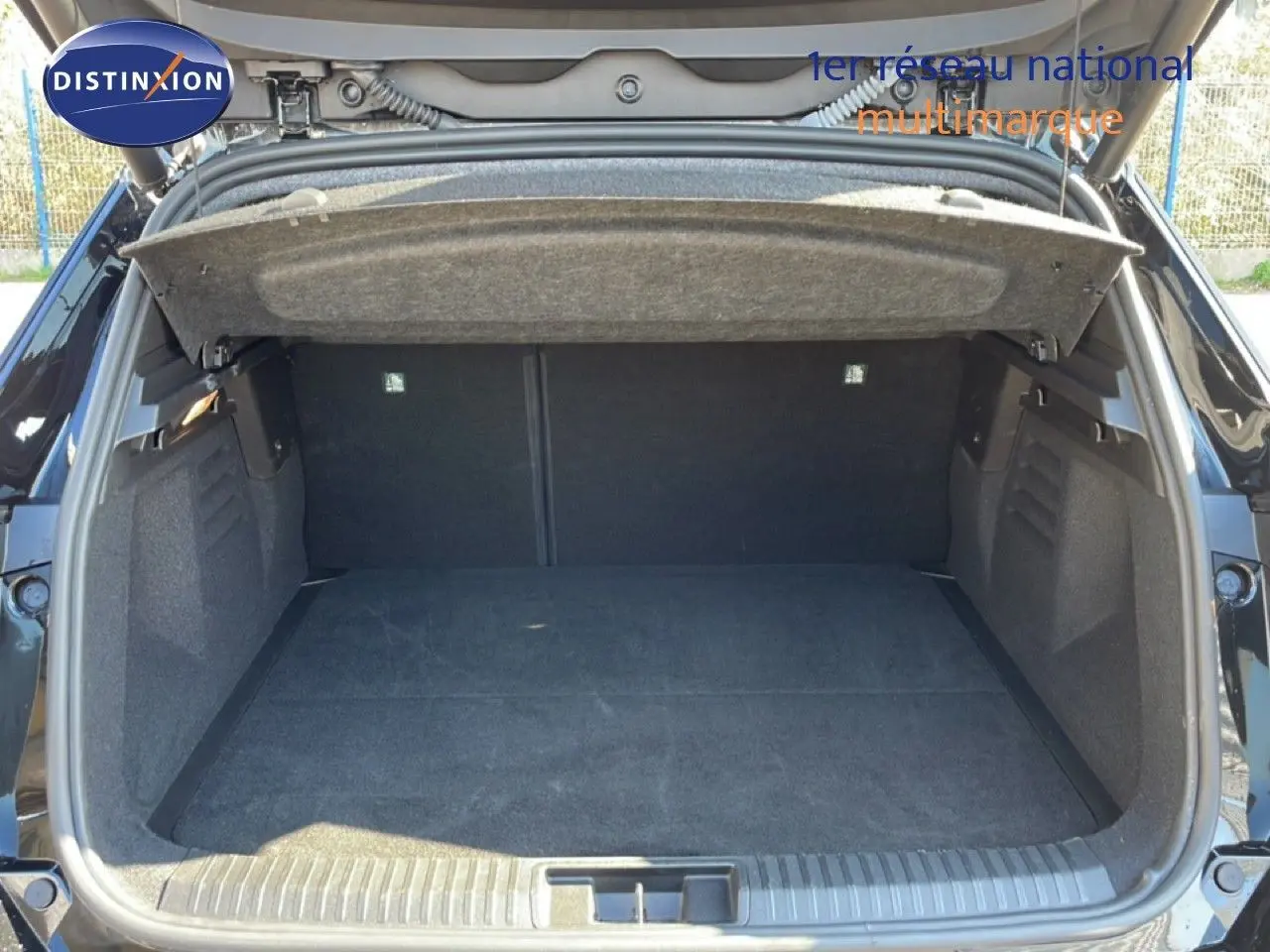 Coffre ouvert vu de l'arrière d'une Renault Symbioz noire étoile métal, montrant l'espace de chargement vide.