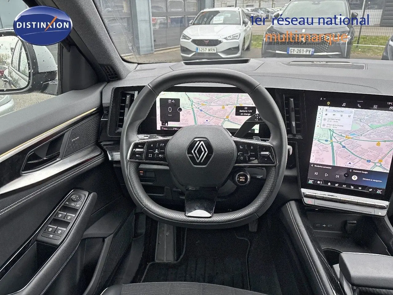 Vue intérieure centrée sur le volant et les écrans numériques du tableau de bord du Renault Austral noir étoile métal 2023.