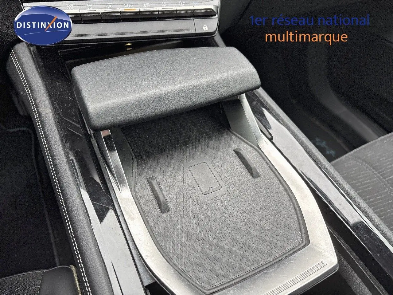 Détail de la console centrale noire avec accoudoir et surface de recharge sans fil du Renault Austral 2023.