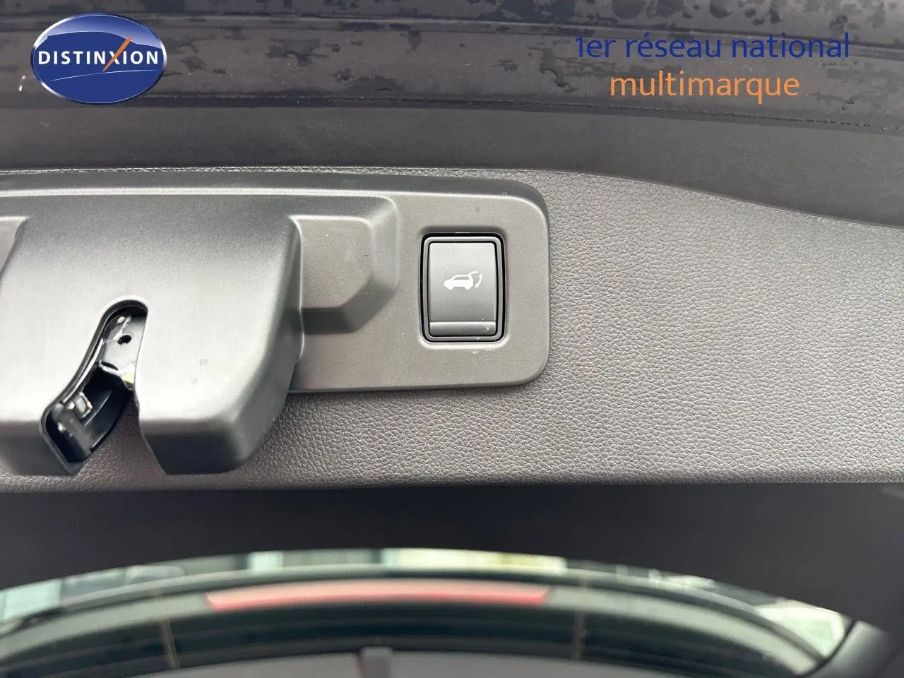 Bouton d'ouverture électrique du hayon sur la garniture intérieure d'un Renault Austral noir étoile métal 2023.