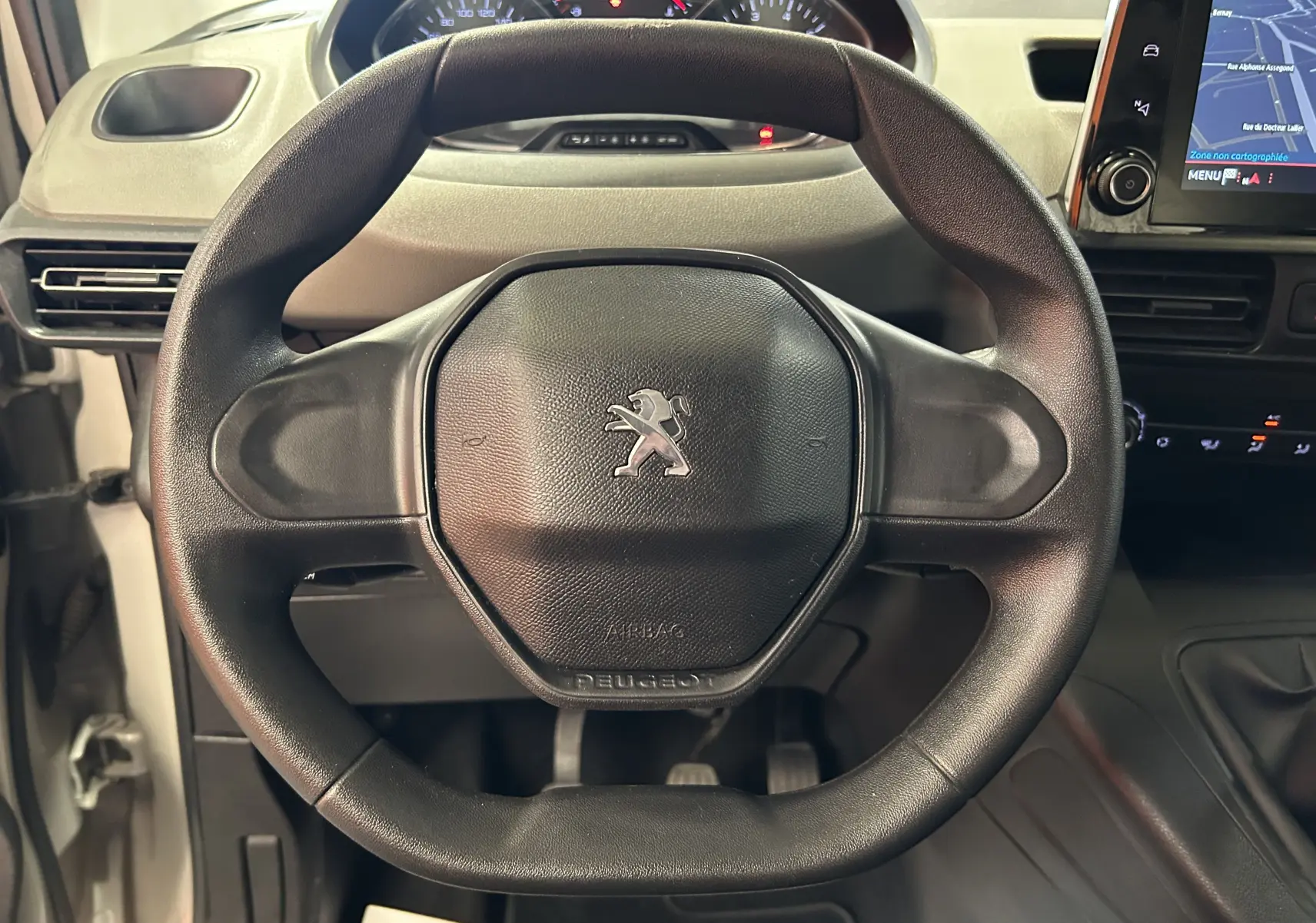 Vue rapprochée du volant noir du Peugeot Rifter 2019 avec tableau de bord et écran GPS visible à droite.