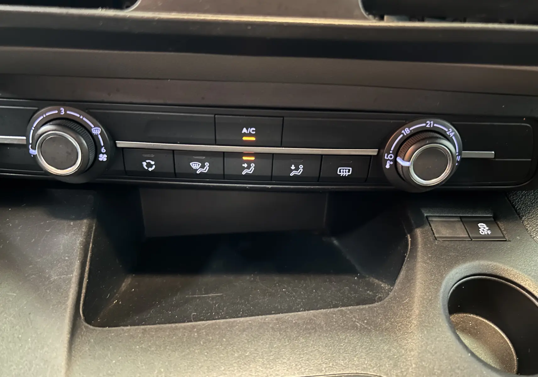 Tableau de bord du Peugeot Rifter gris sable 2019 montrant les commandes de climatisation avec réglages manuels et air conditionné activé.