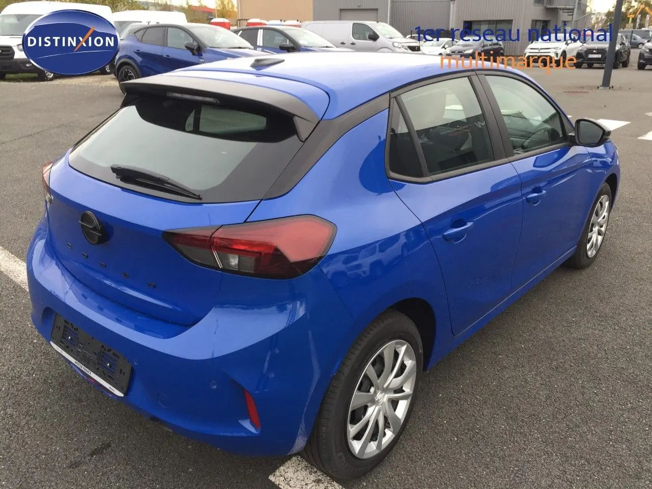 Opel Corsa bleu voltaik métal vue 3/4 arrière droit, compacte cinq portes avec feux arrière LED et toit noir.