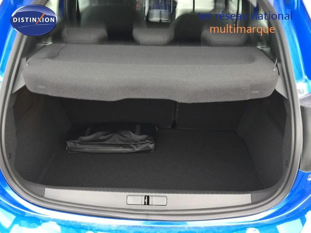 Coffre ouvert d'une Opel Corsa bleu voltaik métal 2025, vue arrière montrant l'espace de chargement et la tablette cache-bagages.