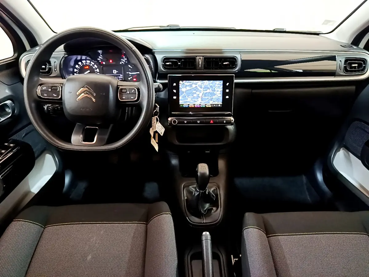 Intérieur avant de la Citroën C3 blanche 2019, vue du tableau de bord avec écran tactile et volant multifonctions.