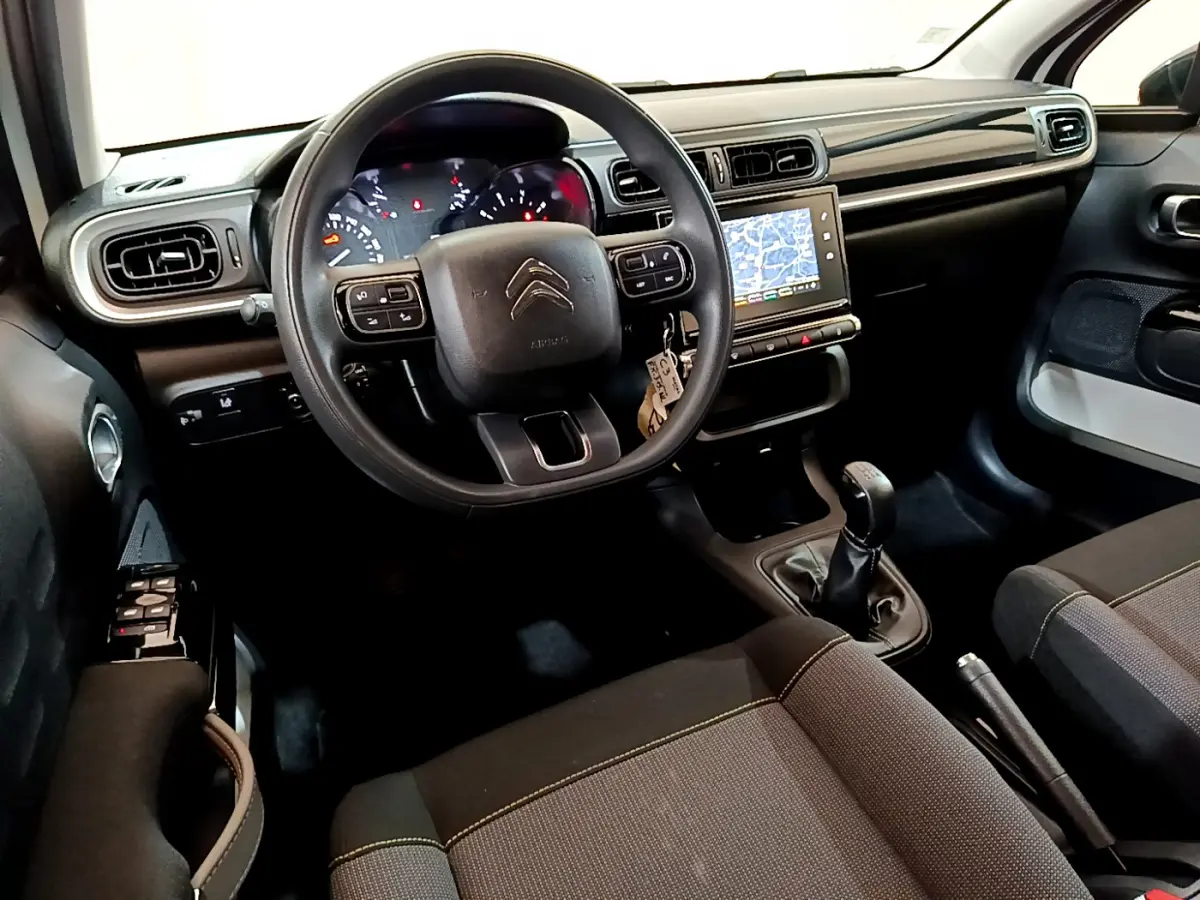 Intérieur de la Citroën C3 2019 vu côté conducteur, volant multifonctions, écran tactile 7 pouces et boîte manuelle noire.