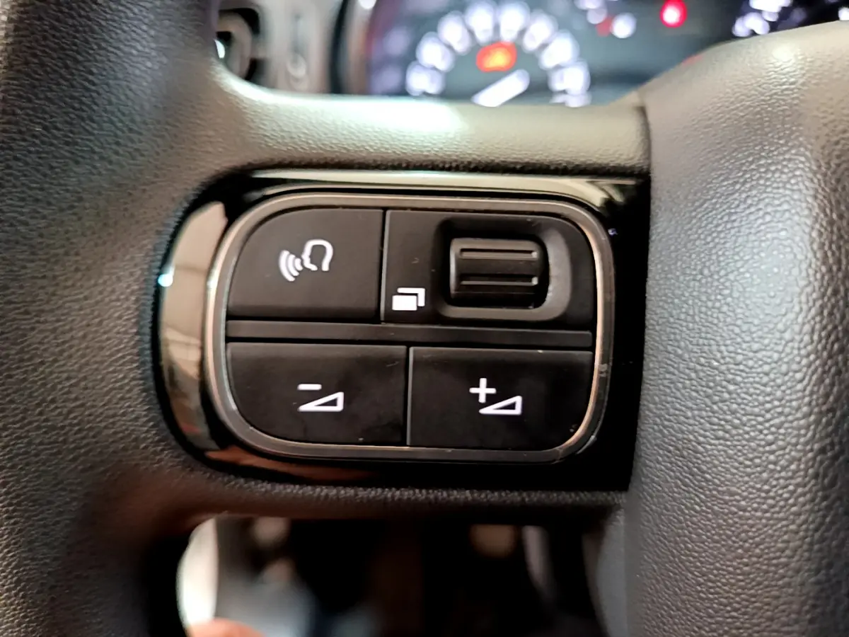 Gros plan sur les commandes vocales et volume au volant de la Citroën C3 blanche, version Feel Business 2019.