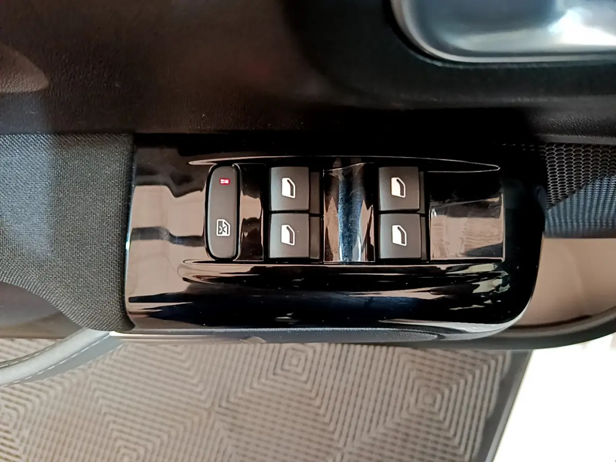 Gros plan sur les commandes de lève-vitres électriques côté conducteur d'une Citroën C3 blanche de 2019.