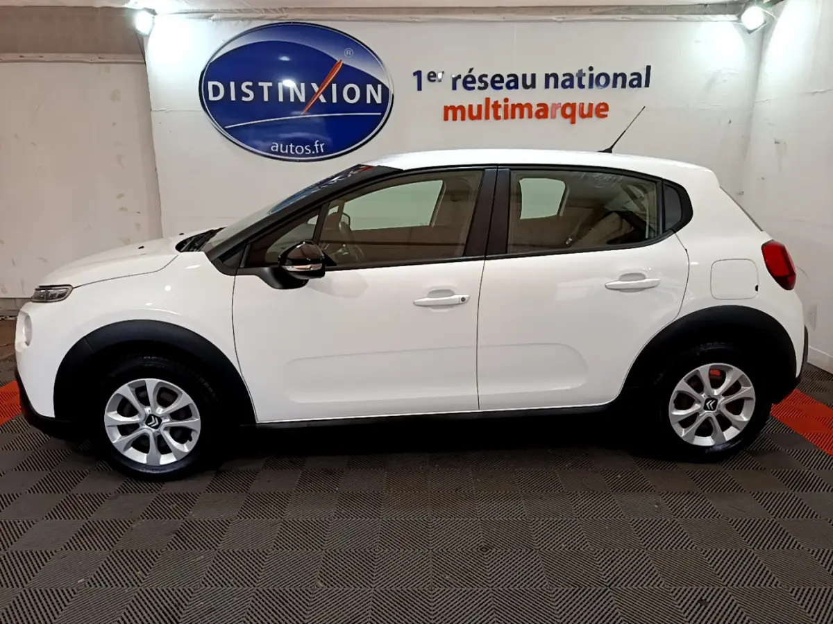 Profil droit d'une Citroën C3 blanche 2019 avec jantes alliage et rétroviseurs noirs dans un showroom.