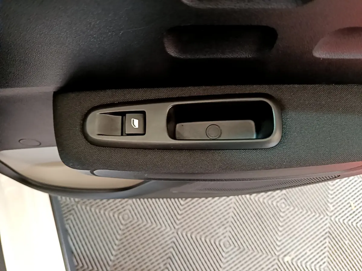Gros plan sur la commande de lève-vitre côté gauche de la porte intérieure d'une Citroën C3 blanche 2019.