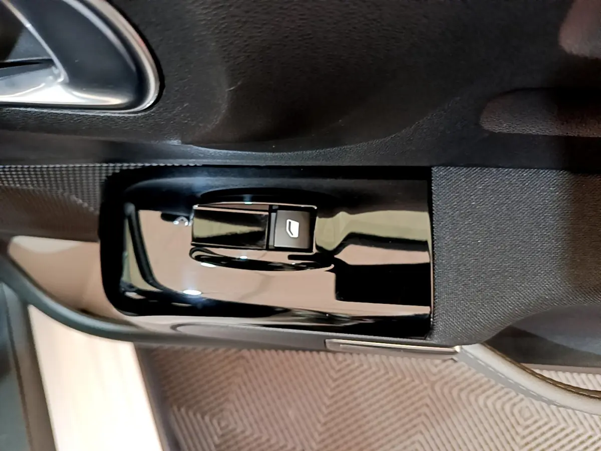 Gros plan sur la commande de lève-vitre côté conducteur de la Citroën C3 blanche, finition Feel Business.