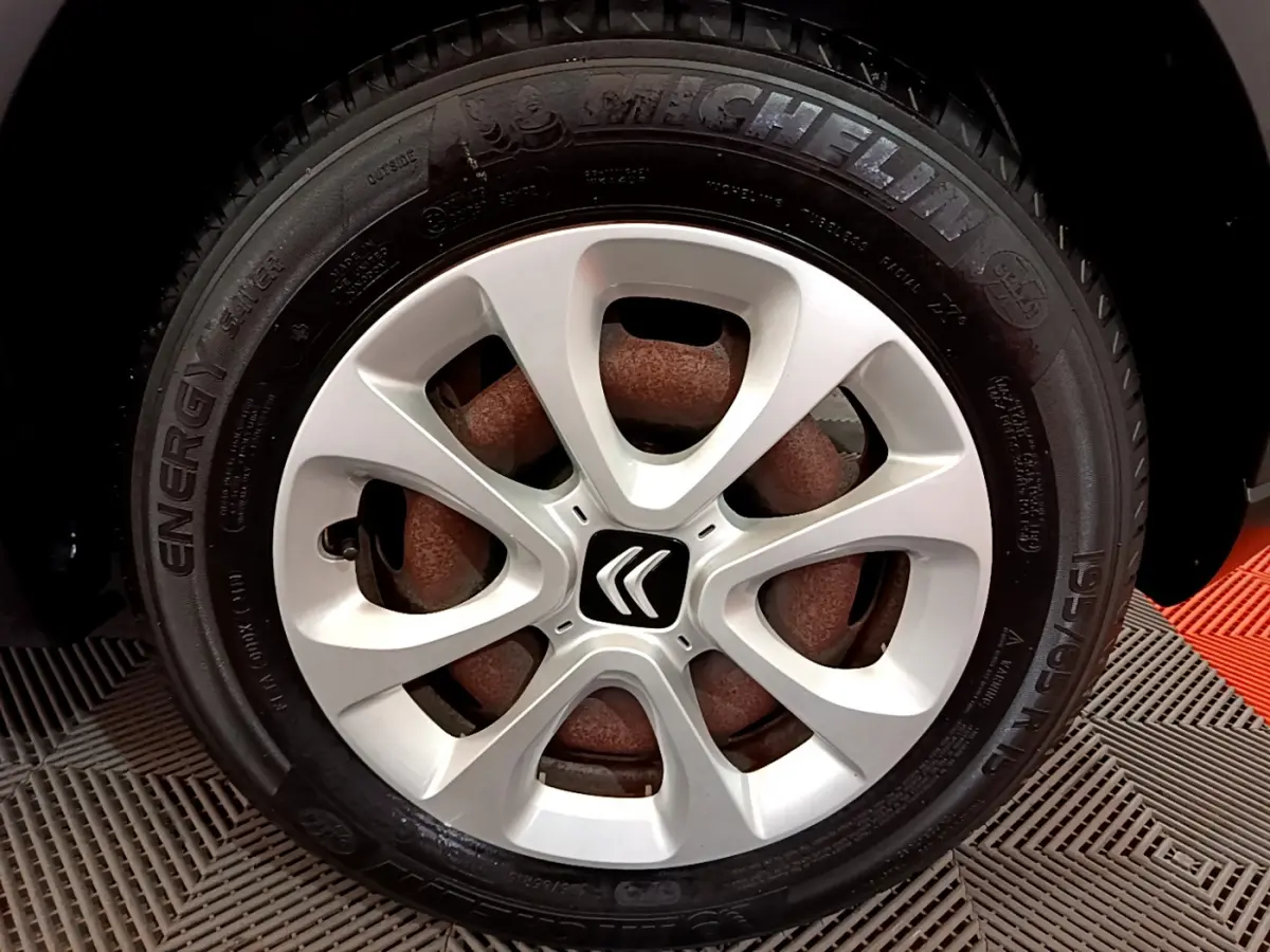 Gros plan sur la roue avant droite d'une Citroën C3 blanche, avec jante en alliage et pneu Michelin Energy.