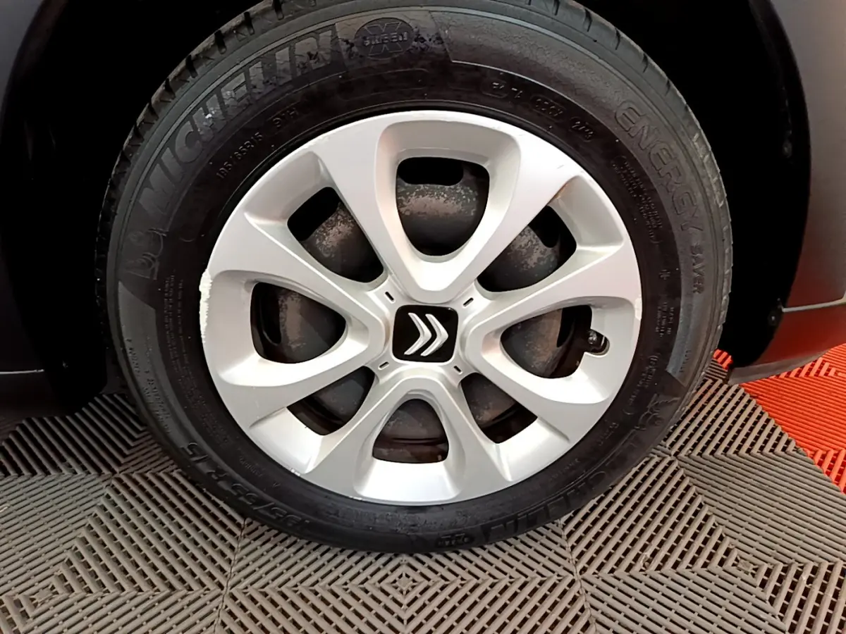 Gros plan sur la roue avant droite d'une Citroën C3 blanche, mettant en valeur la jante et le logo Citroën central.