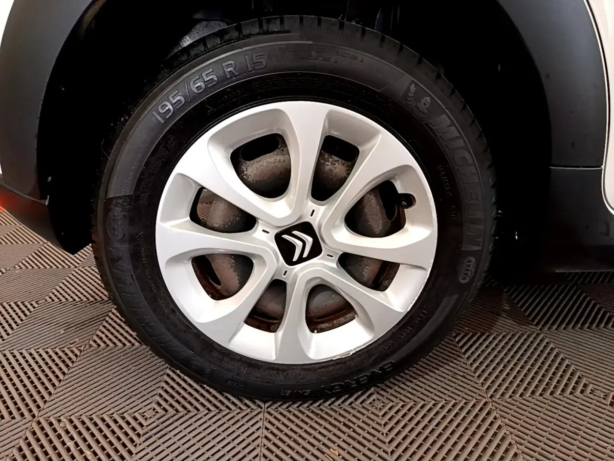 Gros plan sur la roue avant droite d'une Citroën C3 blanche de 2019 avec jante alliage et pneu Michelin.