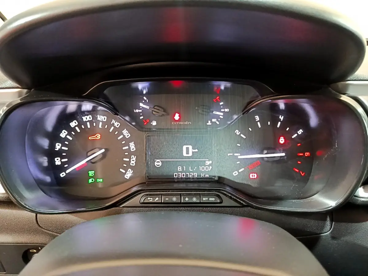 Tableau de bord de Citroën C3 blanc 2019, vue frontale, affichage numérique et compteurs analogiques éclairés.