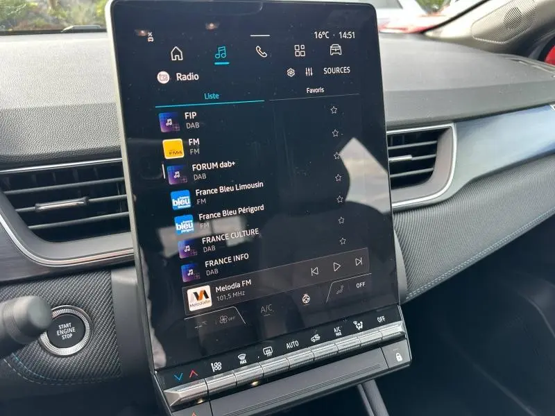 Vue intérieure du tableau de bord du Renault Captur 2026, écran tactile central affichant les radios, avec finition Gris Rafale/Noir Etoilé.