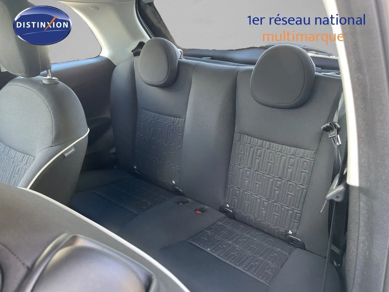 Vue intérieure arrière montrant les sièges noirs avec motifs FIAT embossés sur la banquette arrière.