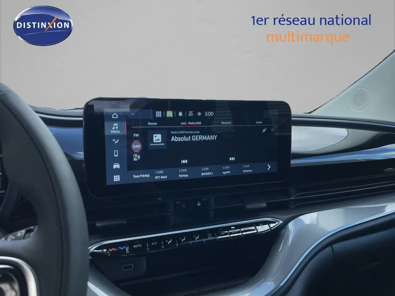 Vue intérieure du tableau de bord de la Fiat 500 électrique 2023, avec écran tactile central affichant une radio numérique.