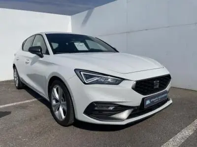 SEAT Leon IV blanc Nevada vue 3/4 avant, jantes alliage 17 pouces et calandre noire distinctive.