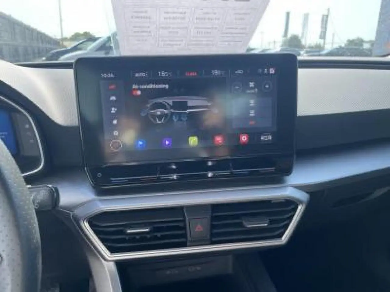 Vue intérieure centrée sur l'écran tactile 10 pouces du tableau de bord du SEAT Leon blanc Nevada 2024.