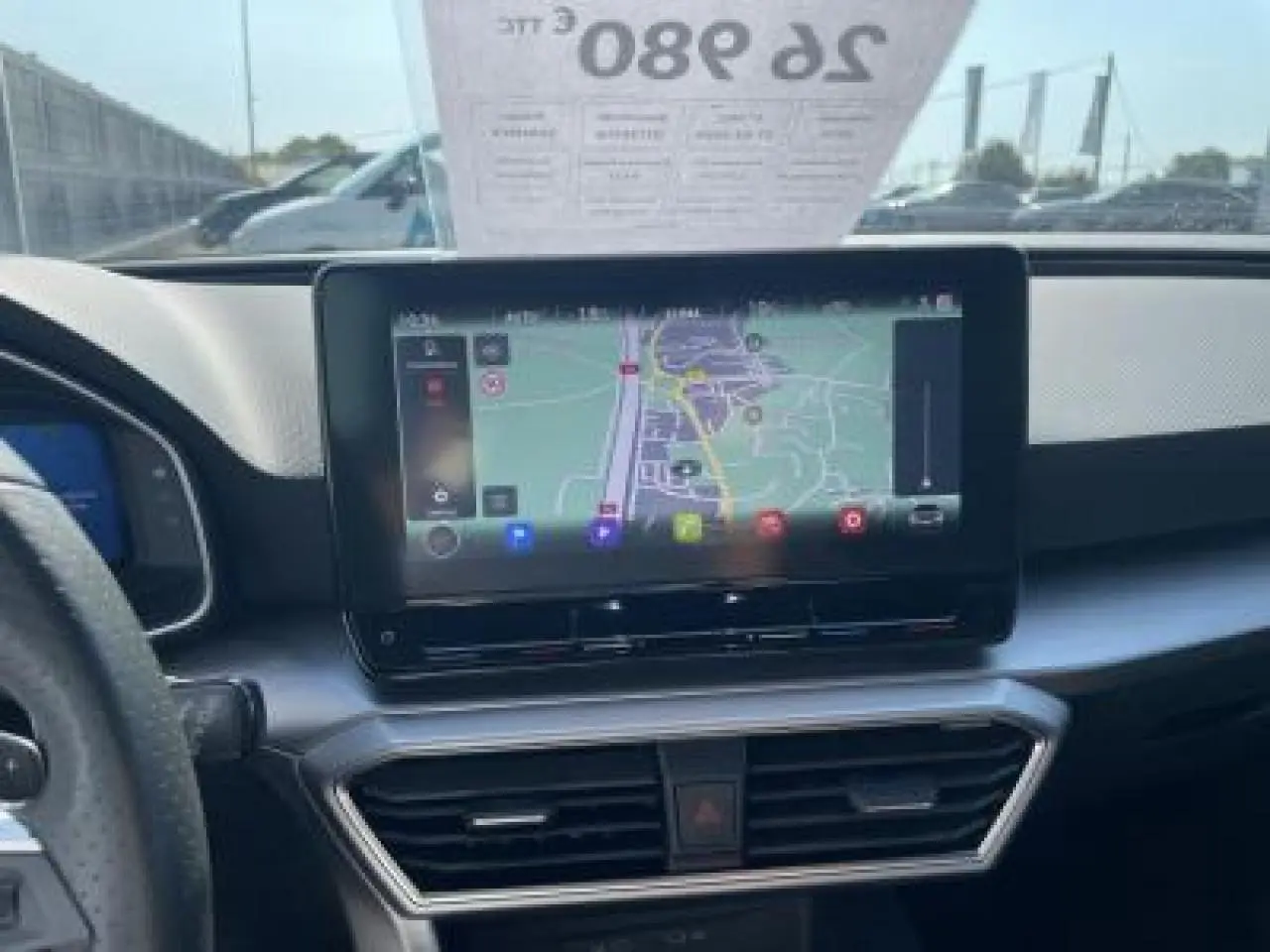 Vue intérieure du tableau de bord du SEAT Leon IV blanc Nevada, mettant en valeur l'écran tactile de navigation central.