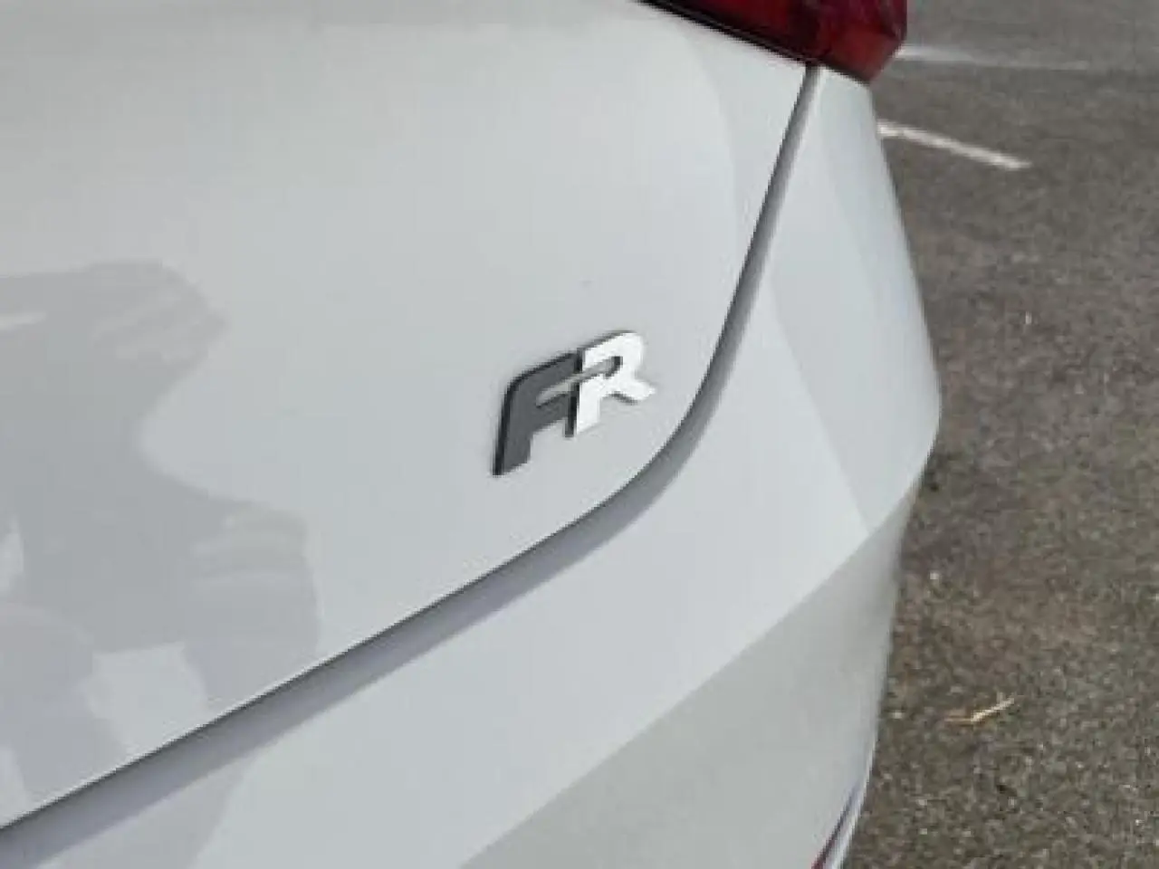 Gros plan sur l'arrière droit blanc Nevada d'une SEAT LEON IV avec le logo FR visible sur le coffre.