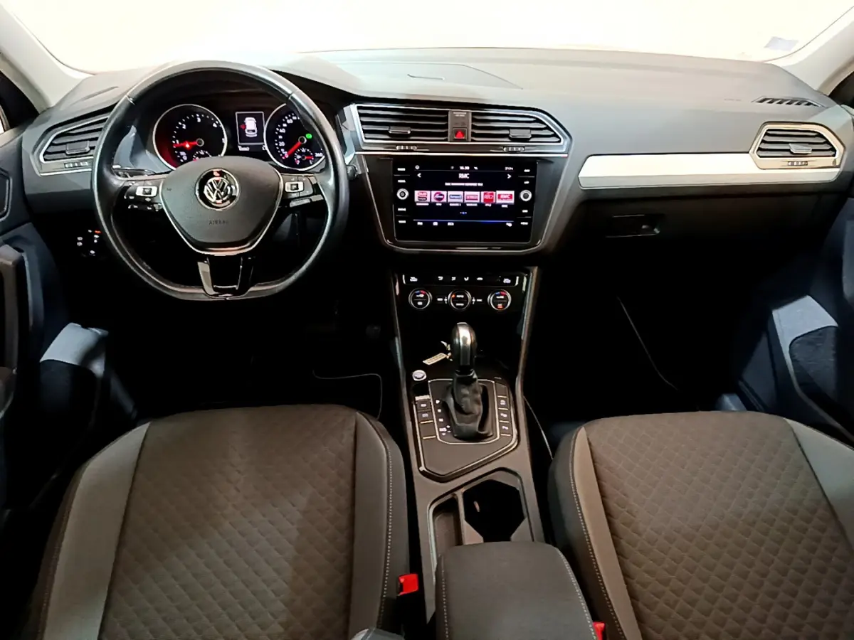 Intérieur Volkswagen Tiguan 2020 vu de face, tableau de bord noir avec écran tactile et volant cuir multifonctions.