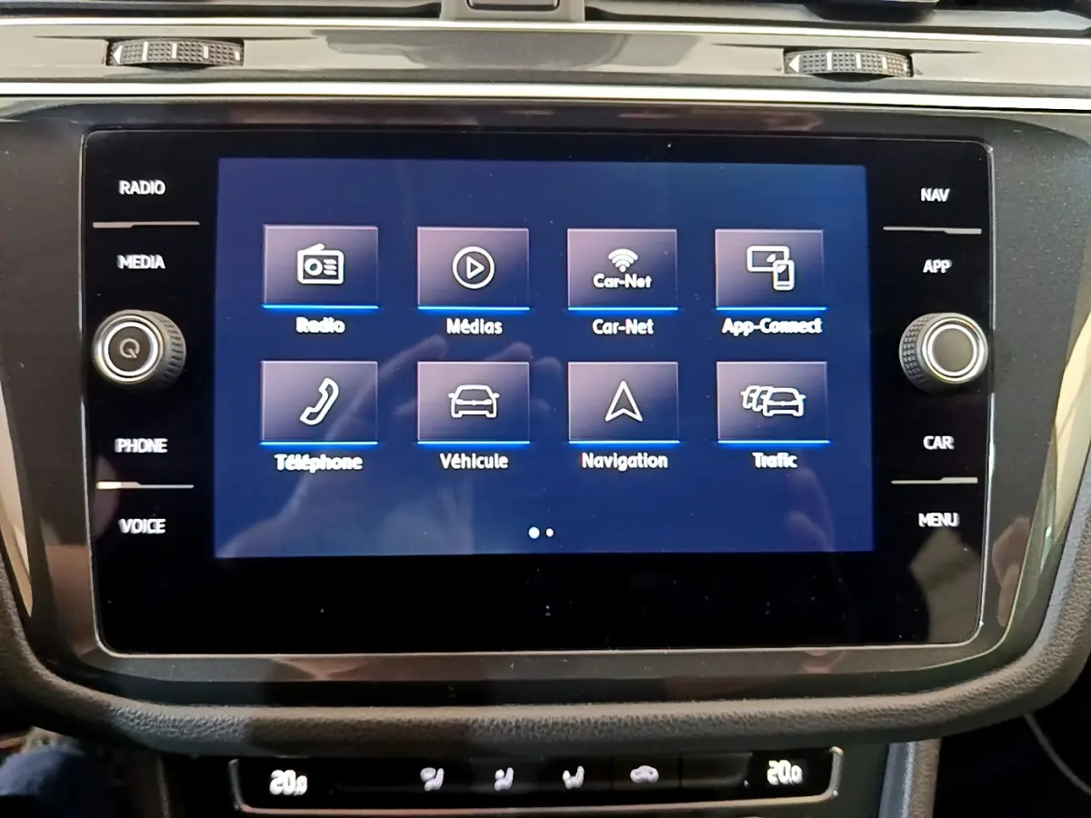 Écran tactile central du tableau de bord du Volkswagen Tiguan gris clair, affichant les options multimédia et navigation.