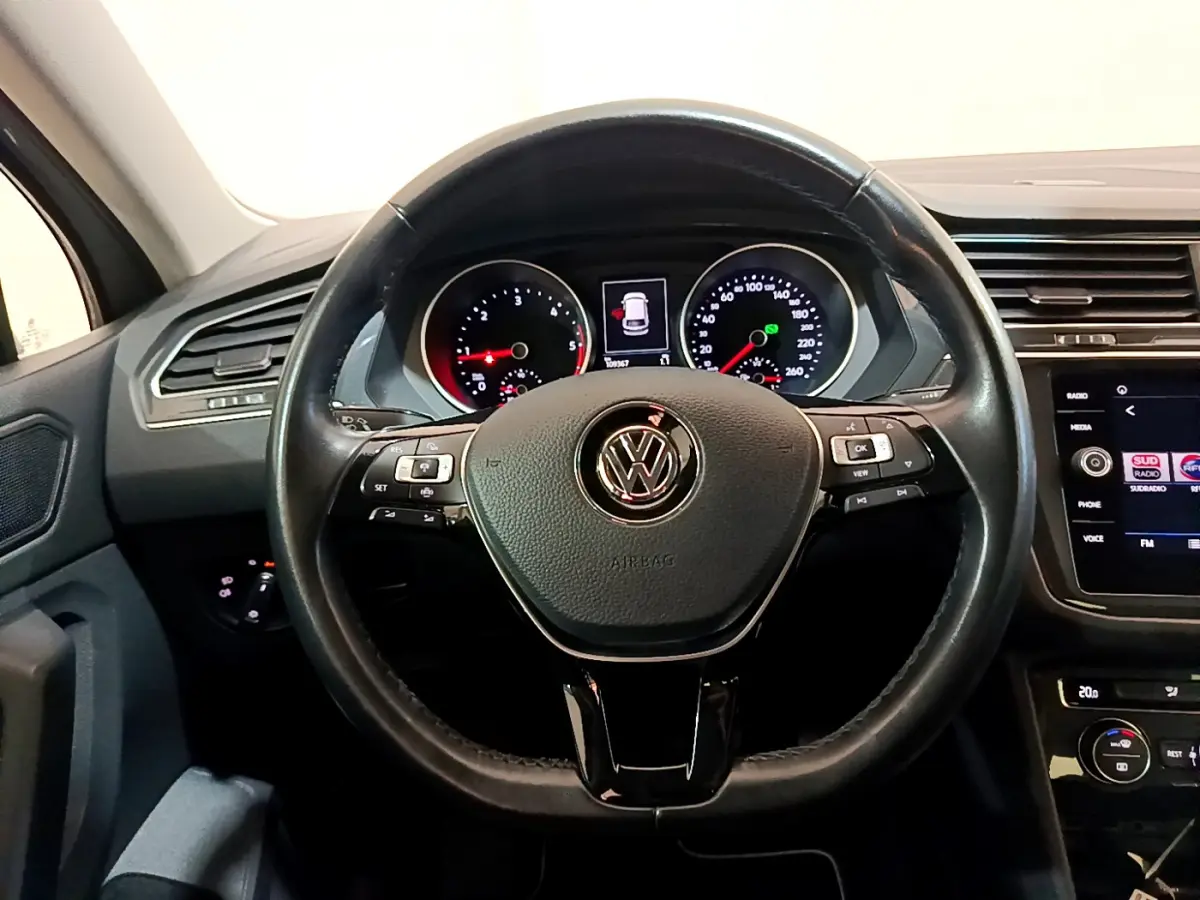 Vue intérieure centrée sur le volant cuir noir et le tableau de bord digital du Volkswagen Tiguan gris clair 2020.