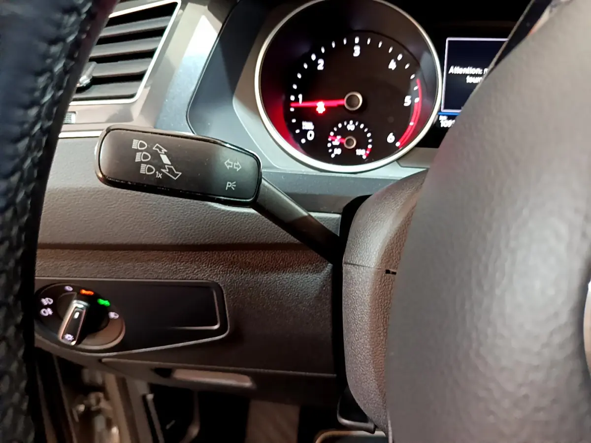 Gros plan sur le commodo gauche et le compteur du tableau de bord du Volkswagen Tiguan gris clair 2020.