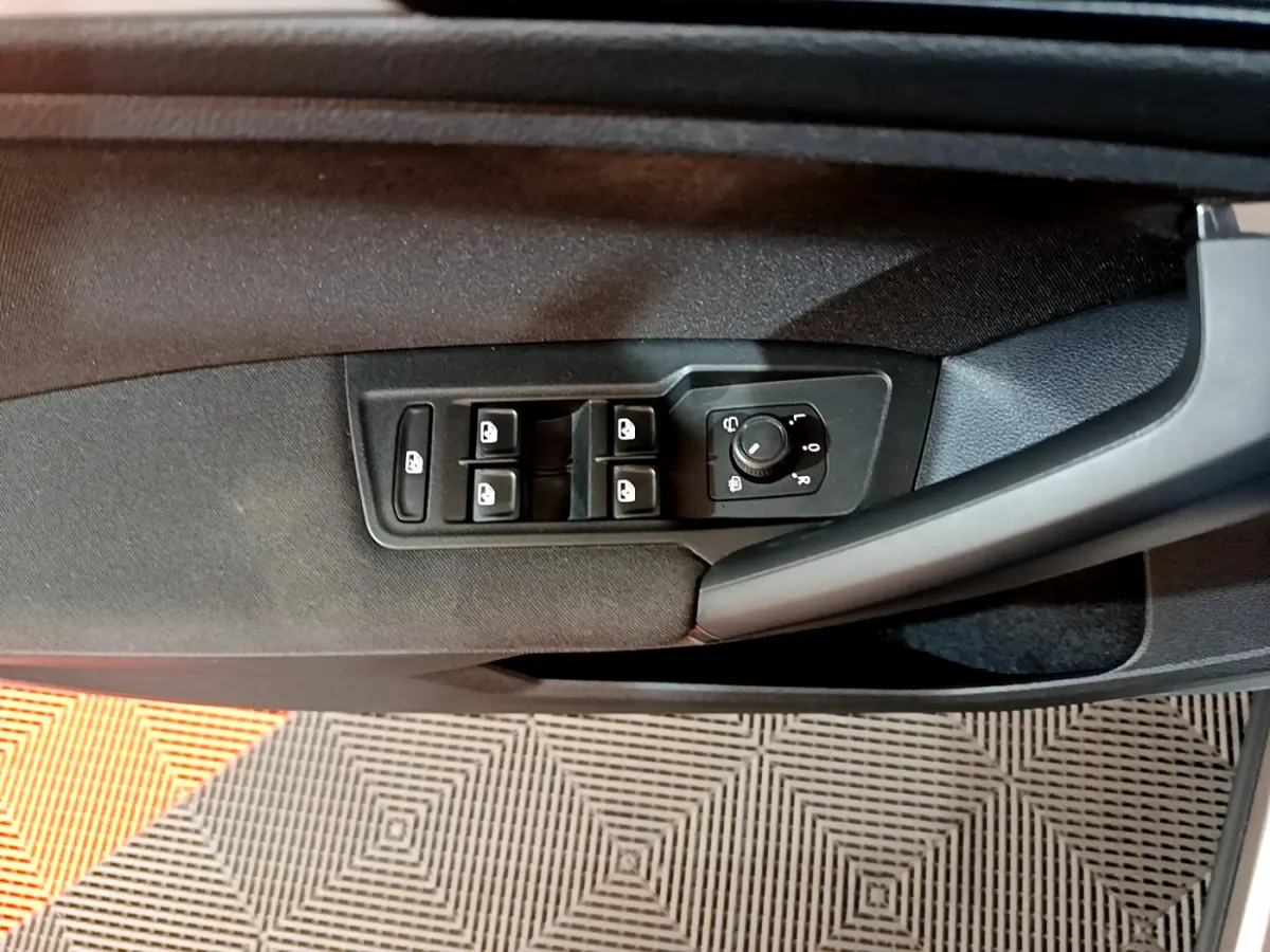 Panneau de porte côté gauche du Volkswagen Tiguan gris clair 2020 avec commandes électriques des vitres et réglage des rétroviseurs.