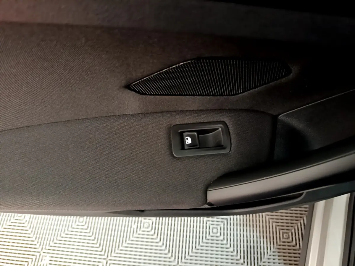 Détail de la poignée intérieure de porte arrière droite du Volkswagen Tiguan gris clair 2020.