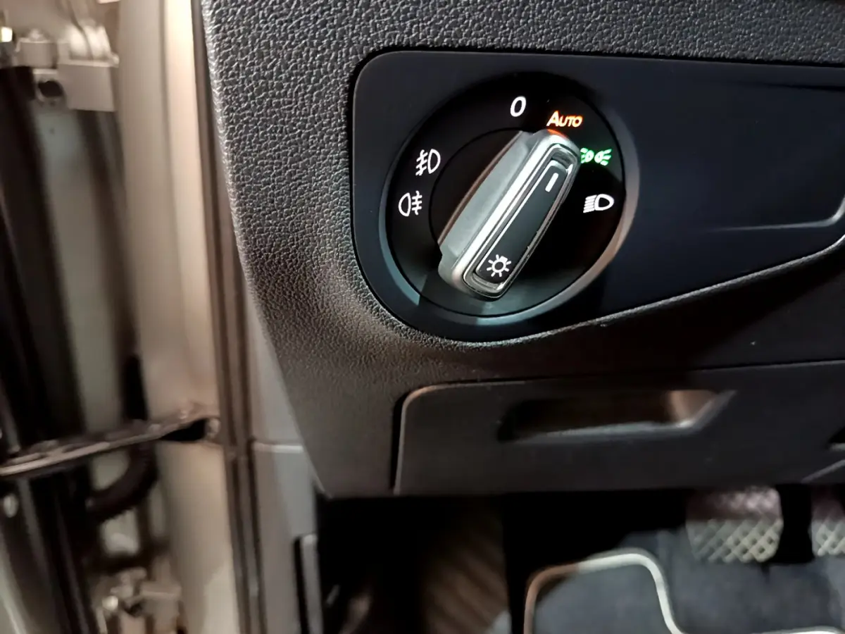 Gros plan sur le sélecteur de phares noir dans l'habitacle du Volkswagen Tiguan gris clair 2020.