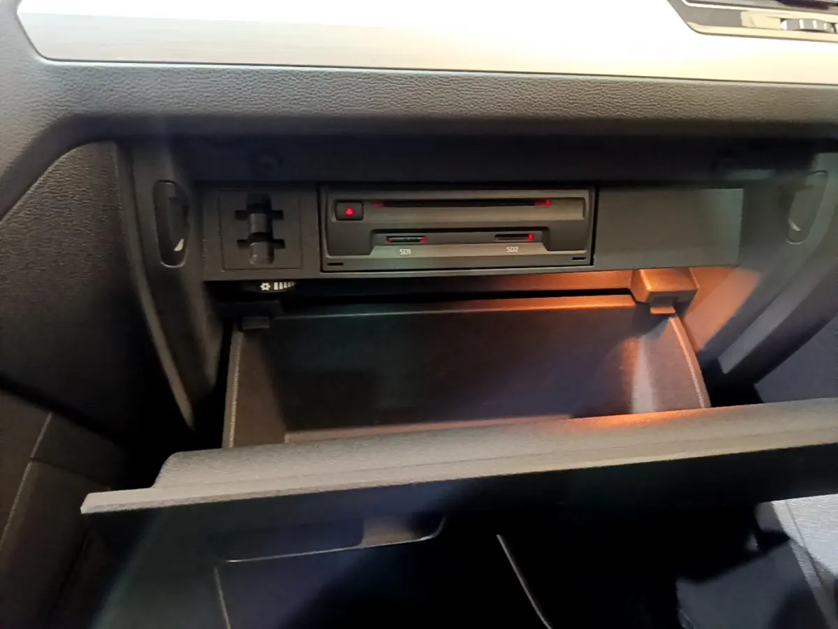 Gros plan sur la boîte à gants ouverte du Volkswagen Tiguan gris clair, montrant les lecteurs de cartes SD intégrés.