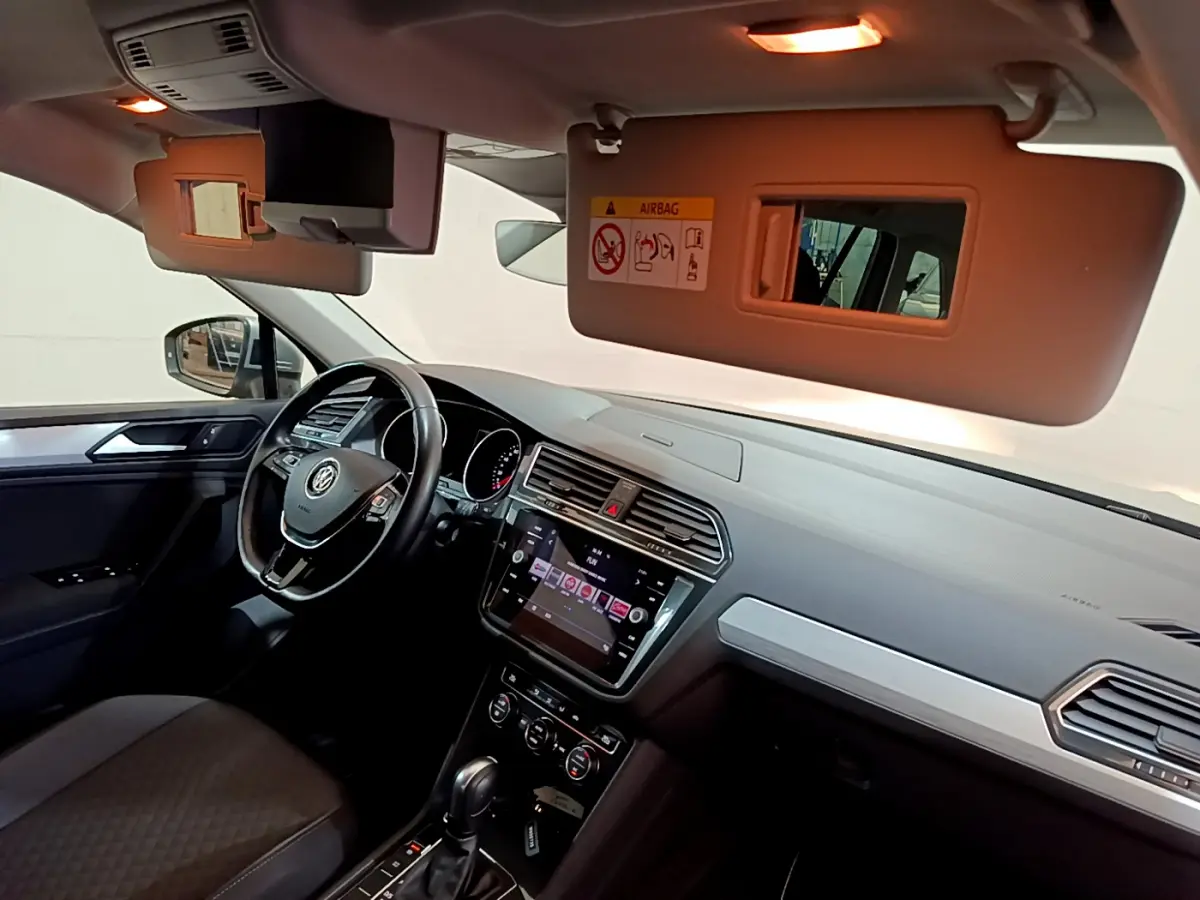 Intérieur du Volkswagen Tiguan 2020 vu côté conducteur, tableau de bord gris avec écran tactile et volant cuir noir.