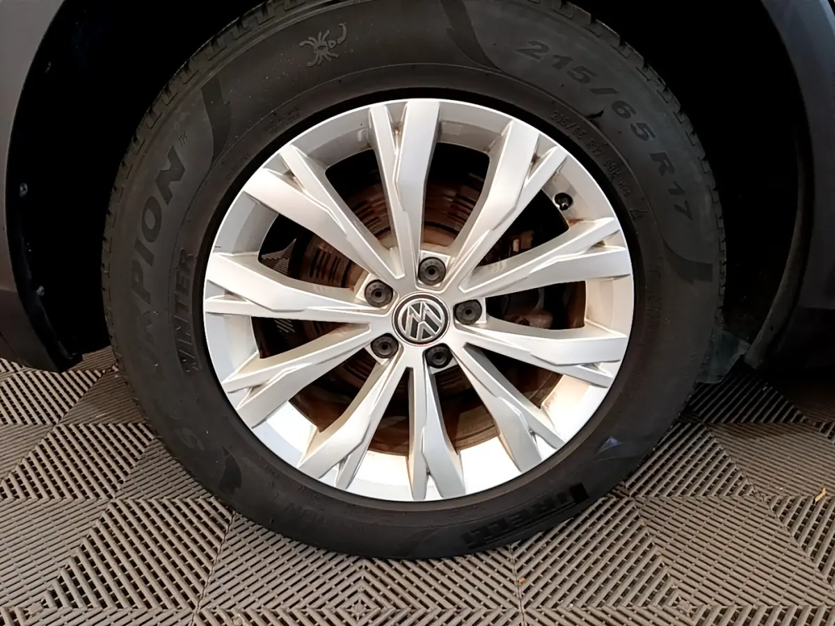 Gros plan sur la jante argentée et le pneu hiver Pirelli d'un Volkswagen Tiguan gris clair 2020.