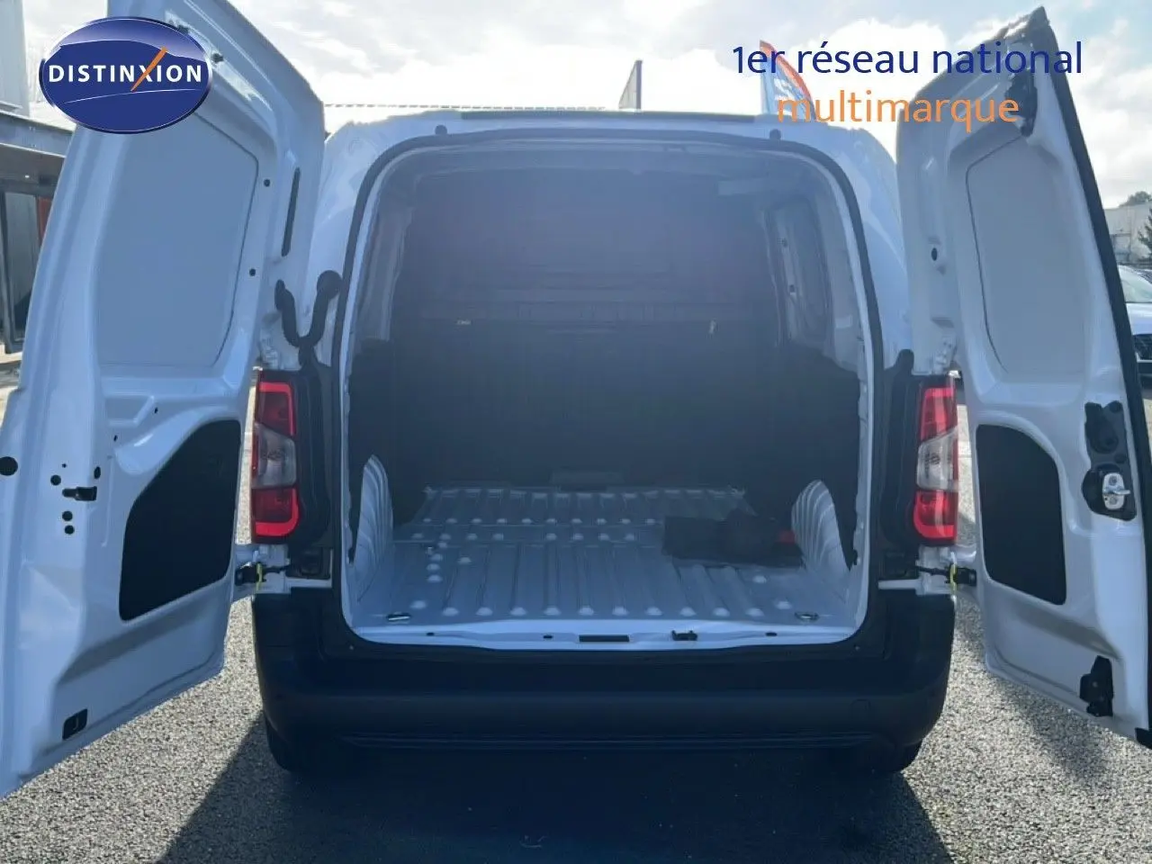 Vue arrière d’un Citroën Berlingo blanc Icy 2025 avec portes arrière ouvertes montrant l’espace de chargement vide.