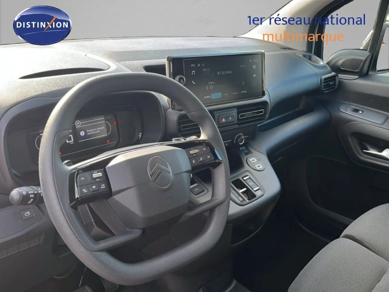 Vue intérieure côté conducteur du Citroën Berlingo blanc Icy 2025, tableau de bord moderne avec écran tactile central.