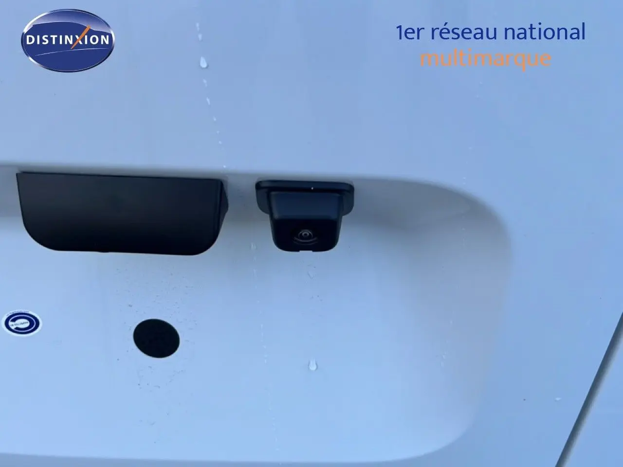 Gros plan sur la caméra de recul noire intégrée à la porte arrière d’un Citroën Berlingo blanc Icy.